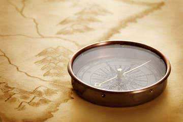 antique compass on vintage paper background