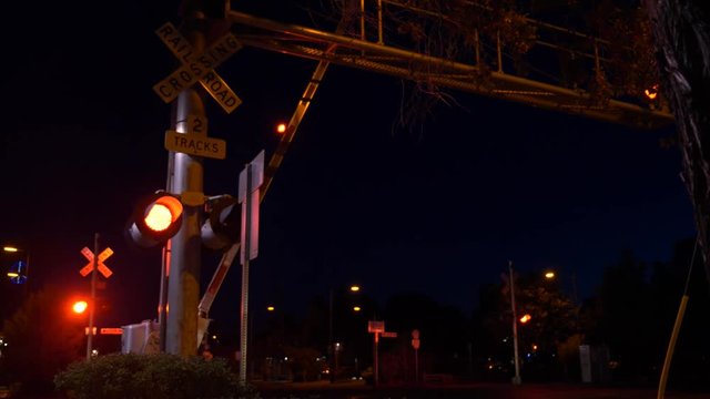 A railroad crossing gate at night