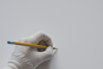 Hand in white glove with pencil copy space