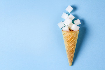 waffle ice cream cone with sugar on a blue background. place for text