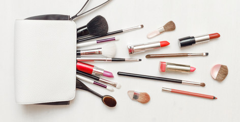 Make up or visage background. Female bag and different make up accessories, brushes, lipstick, and...