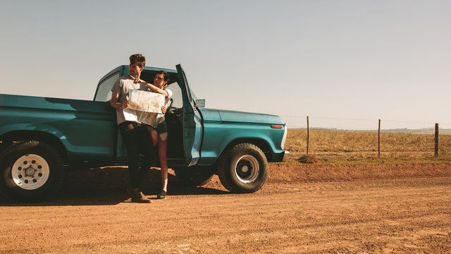Couple on a road trip looking at map for navigation