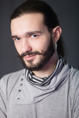 A bearded guy. Hipster model. fashion portrait in studio on a gray background
