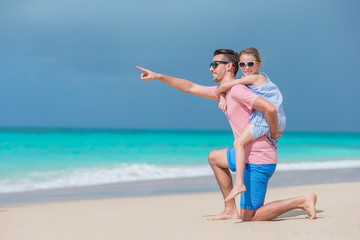 Family of father and sporty little girl having fun on the beach