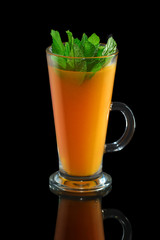 Cup of sea buckthorn tea with ginger isolated on black