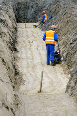 worker tires the sand on a construction site