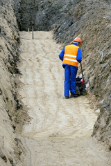 worker tires the sand on a construction site