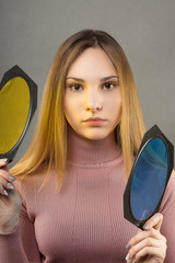 Young model playing with color filters for flashes in the Studio