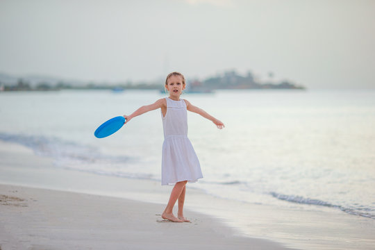 Little girl playing on a tropical white beach