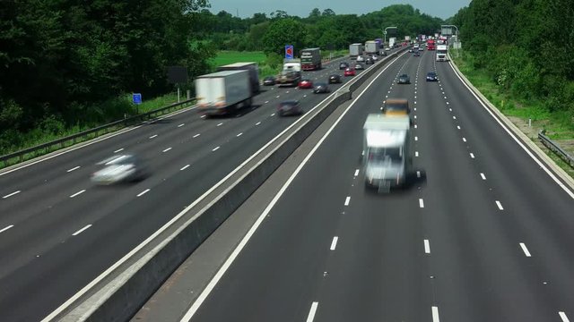 Time lapse of road traffic on the M1 smart four lane motorway with no hard shoulder and electronic active traffic management lane signs in Northamptonshire England.