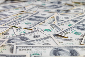 Paper 100 dollar bills spread out on the plane in a chaotic manner