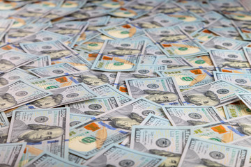 Paper 100 dollar bills spread out on the plane in a chaotic manner