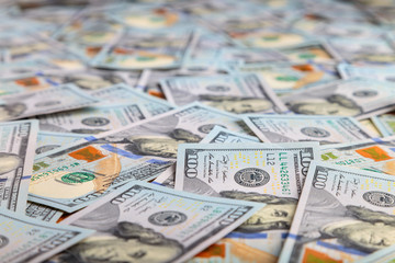 Paper 100 dollar bills spread out on the plane in a chaotic manner