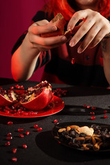 A young girl with red hair is preparing mulled wine. Red and black palette