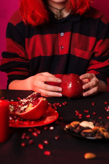 A young girl with red hair is preparing mulled wine. Red and black palette