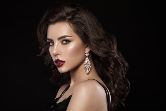 Fashion glamorous portrait of a girl on a dark background. Elegant hairstyle, bright makeup and lip color. Hollywood picture.