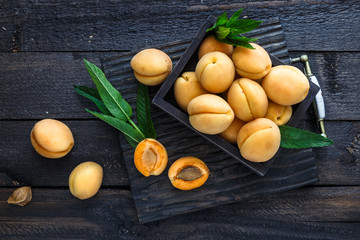 Delicious ripe apricots in a wooden box on dark background