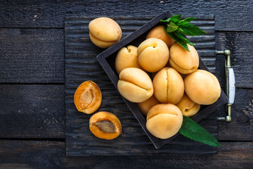 Delicious ripe apricots in a wooden box on the table close-up, copyspace