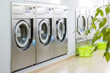 Public laundry with modern, silver washing machines - obrazy, fototapety, plakaty