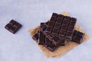 Square stick of chocolate on brown paper. Handmade.