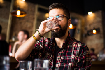Bearded man drinking water in a coffee bar