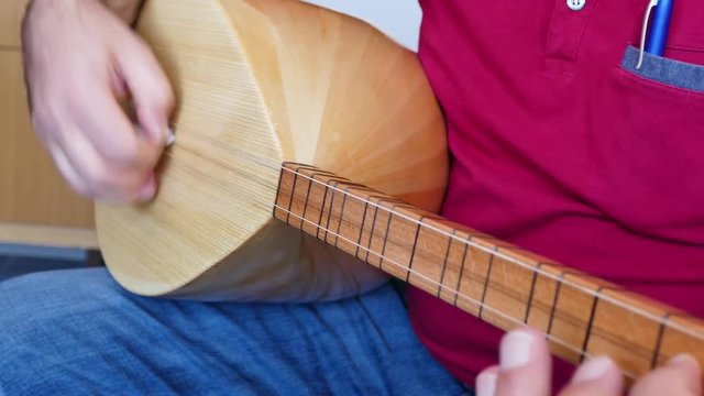 Turkish saz of the musical instrument,
Man playing Turkish saz

