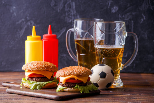 Image of two hamburgers, glasses, soccer ball, ketchup