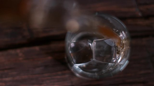 Pouring whisky from the bottle at vintage bar in super slow motion. Shot with high speed cinema camera Phantom VEO 4K , 1000fps.