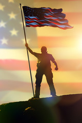 Silhouette of man holding US flag American on the mountain. The concept of Independence Day. a successful silhouette winner, a man waving an American flag on top of a mountain peak