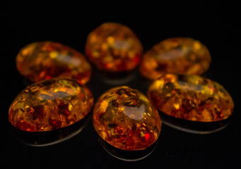 Artificial amber cabochons on a black background macro
