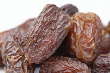 dried dates on a white background,  product of the date palm and cultivated since approximately 6000 B.C