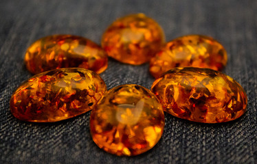 Artificial amber cabochon on a blue background macro