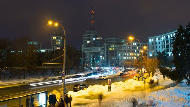 Kharkiv, Ukraine. Freedom square with car traffic and the Derzhprom or Gosprom building is a constructivist structure. Time-lapse at night with people silhouettes and dark sky