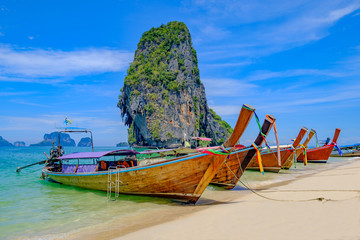 Beautiful landscape with long tail boats on tropical beach of island Krabi, Thailand.