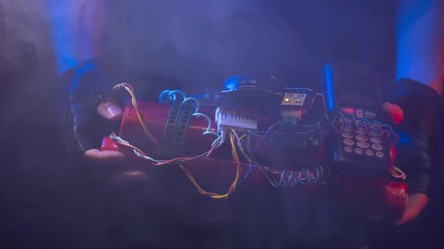 Terrorist showing a time bomb phone activated to the camera. Smoke coming out .