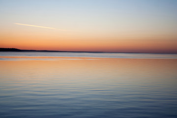 Scenic sunset above still sea on summer evening