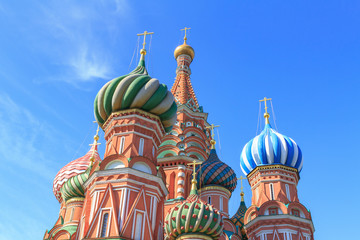Fototapeta na wymiar Domes of St. Basil's Cathedral on Red square against blue sky on a sunny summer morning