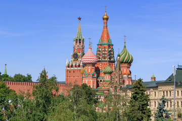 Fototapeta na wymiar St. Basil's Cathedral with Moscow Kremlin on a blue sky background on a sunny summer morning