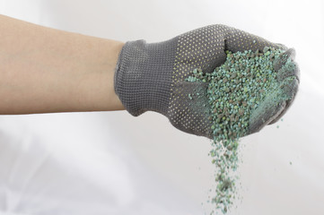 Bun of mineral fertilizer, in the hand on which is put on a mitt.