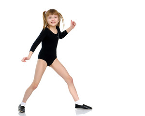 A little girl does gymnastic exercises.