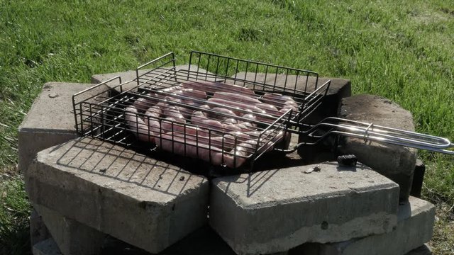 White sausages grilling on the barbeque close up.