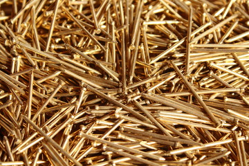 Small nails for furniture of golden color. Close-up. Background. Texture.