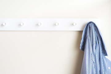 Simple white wall coat hanger with a hanging shirt