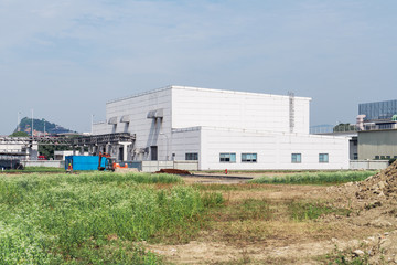 Fototapeta na wymiar Factory building in the suburbs, industrial plant background
