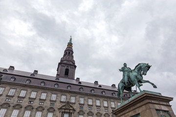 Fototapeta na wymiar Moody wide angle view of the Christiansborg Palace and Frederik VII Statue in Copenhagen, Denmark.