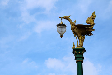 Fototapeta na wymiar Light poles with beautiful asian-style design on the street against a blue sky