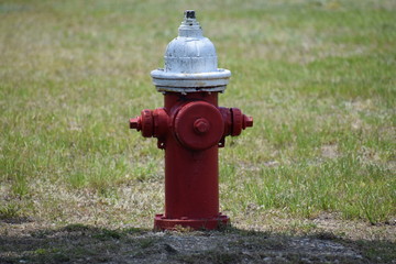 Fototapeta na wymiar Red fire hydrant with white cap and some rust