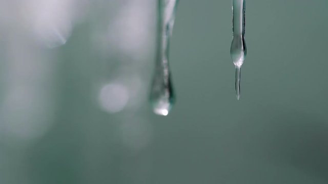 Macro slow motion video of pure drops dripping from small icycles
