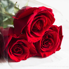 Three red roses bouquet white background copy space.