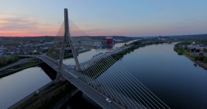 Aerial view of steel cable bridge crossing in Belgium. Road in perspective. European bridge over a river at sunset.
